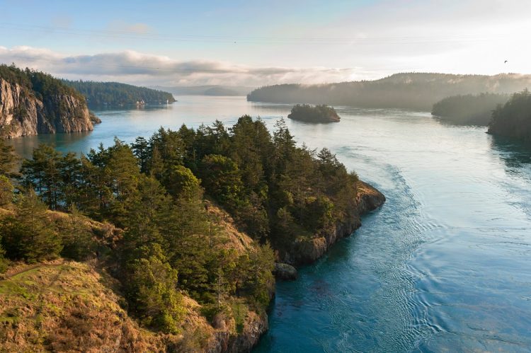Deception Pass State Park with treed rocks jutting into ocean water.