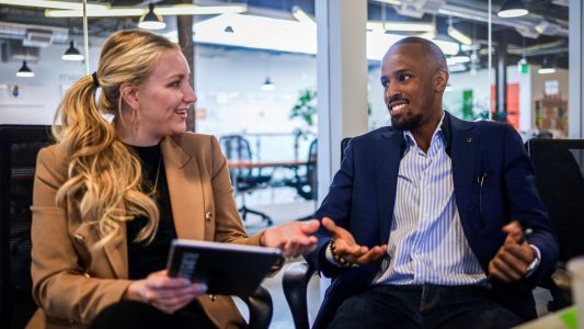 Photo of two people conversing.